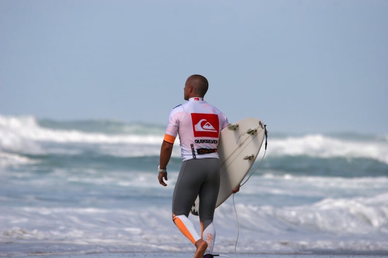 Surfer carving a turn on a large turquoise wave with spray