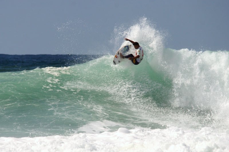 Surfer mid-air above a breaking wave